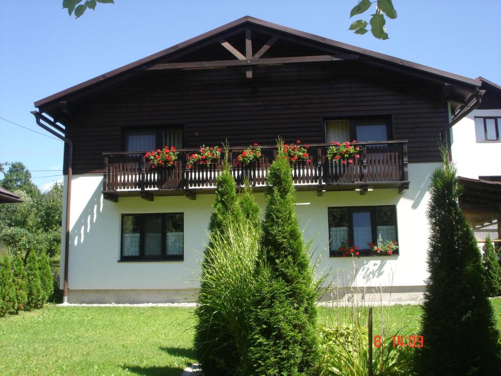 a house with a balcony with flowers on it at E&Z Eva Hruba rekreačný dom in Bystrá