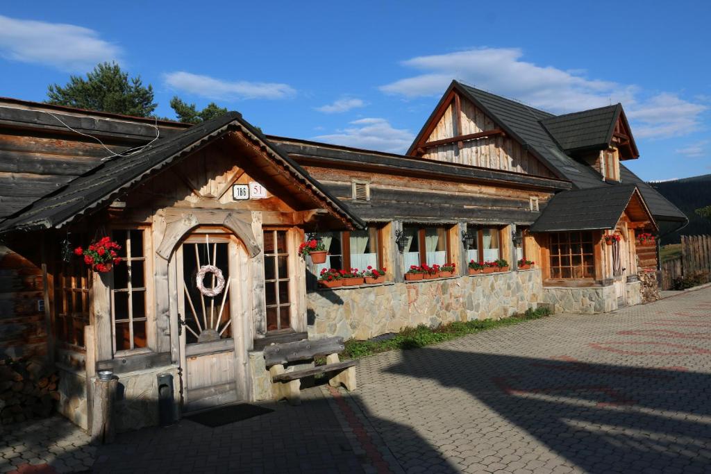 a wooden building with a gate in front of it at Penzión Skorušina in Brezovica