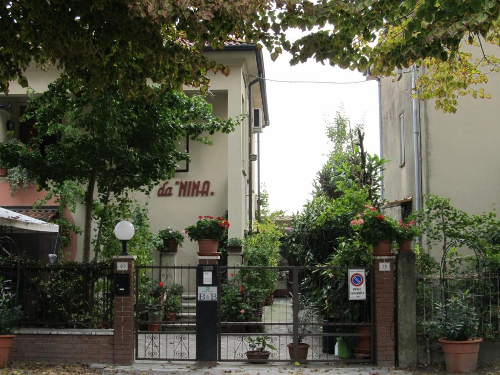 un edificio con macetas y una valla en B&B da NINA, en Sabbioneta
