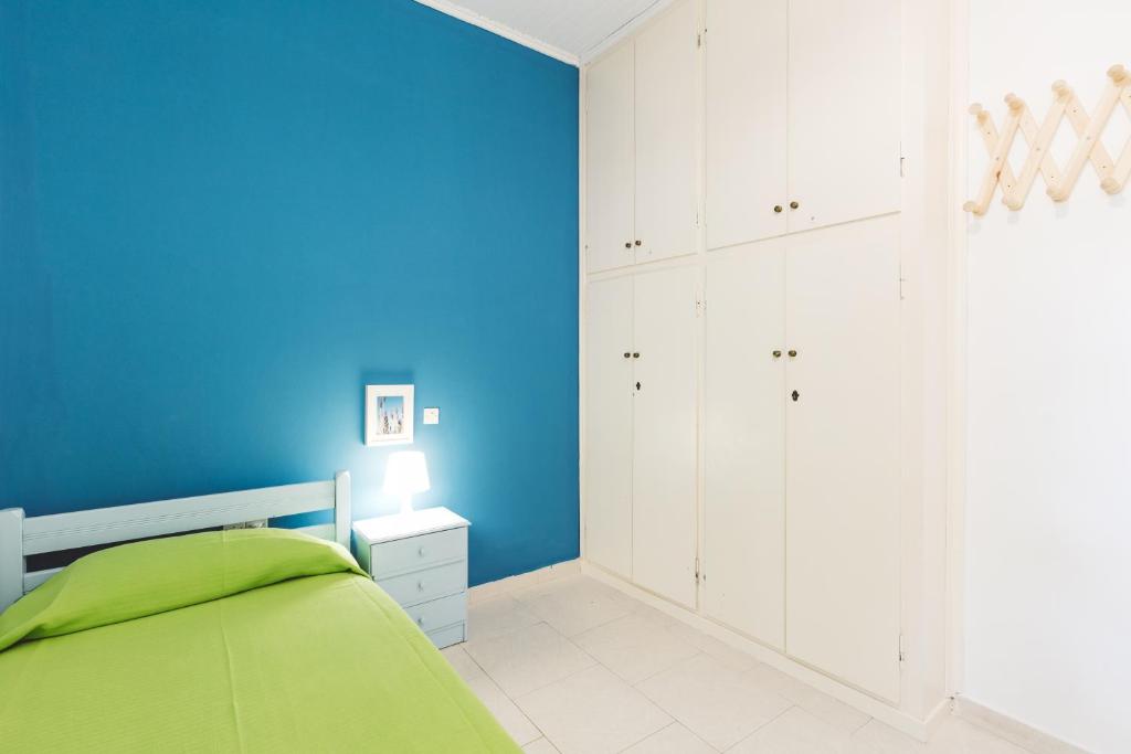 a blue bedroom with a bed and a blue wall at Panorama Apartments updated with infinity pool in Agios Nikolaos