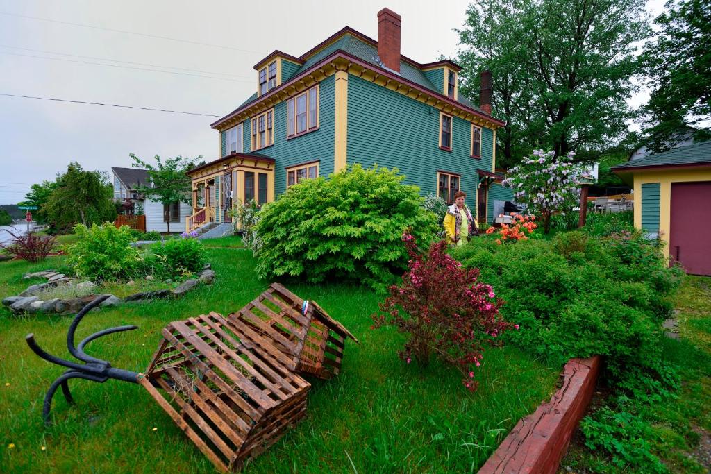 una casa con un banco de madera en el patio en The Spaniards Room Heritage Home, en Spaniards Bay