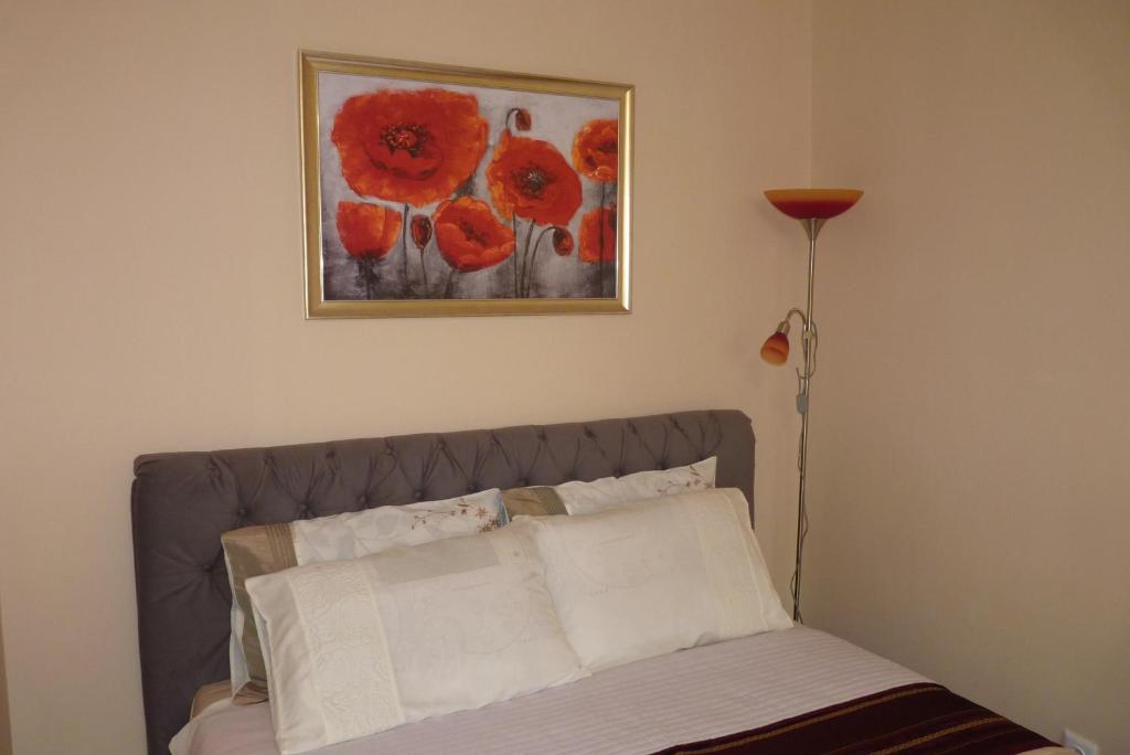 Apartament Planty في زاموسك: سرير في غرفة نوم مع لوحة على الحائط