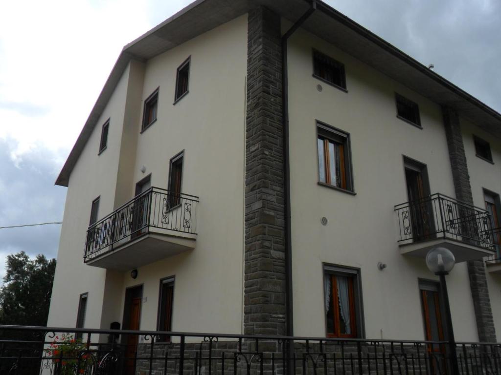 ein großes weißes Gebäude mit zwei Balkonen darauf in der Unterkunft Appartamento Montefumaiolo in Balze