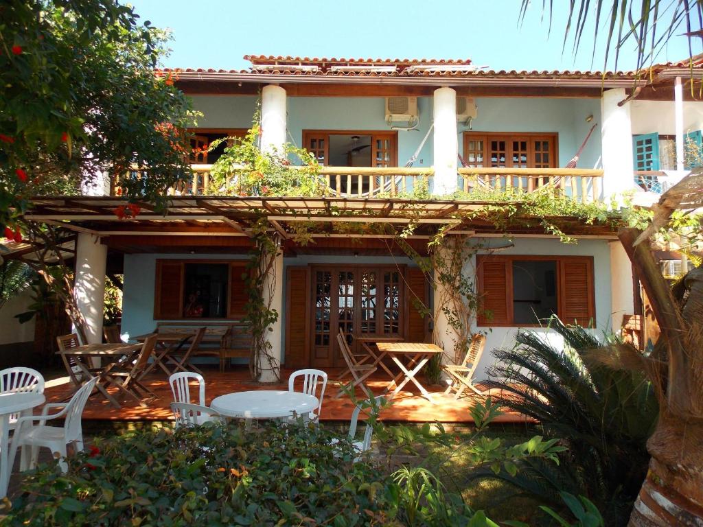 a house with chairs and tables in front of it at Pousada Manaca in Abraão