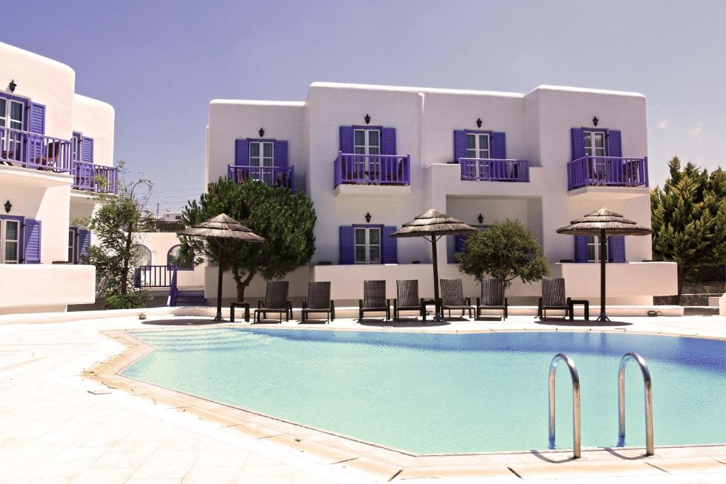 um hotel com piscina em frente a um edifício em Hotel Anatolia em Ano Mera