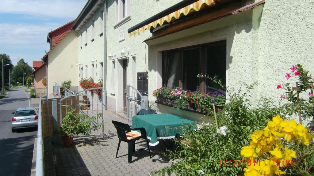 un tavolo e sedie verdi all'esterno di un edificio fiorito di XXL Ferienwohnung a Pirna