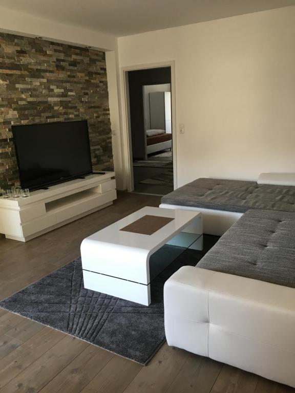 a living room with two beds and a flat screen tv at City Apartment in Augsburg