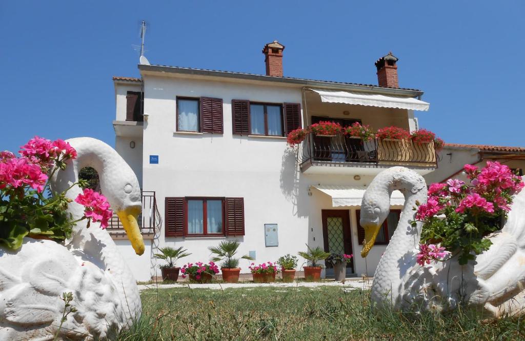 deux statues de cygnes devant une maison dans l'établissement Apartman Mirela, à Rovinj