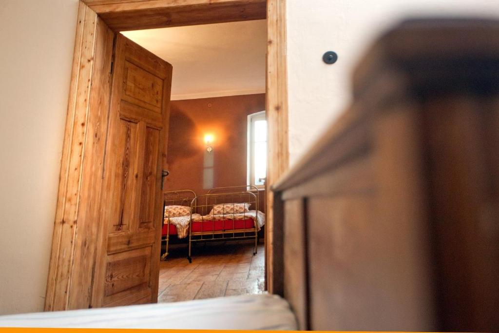 un couloir avec une porte et une chambre avec un canapé dans l'établissement Gosciniec Kaszarnia Kamienne, à Mirsk