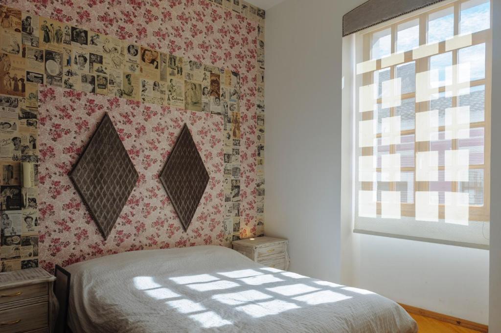um quarto com uma cama e uma parede com uma janela em San Marcos Suite Boutique centro quito em Quito