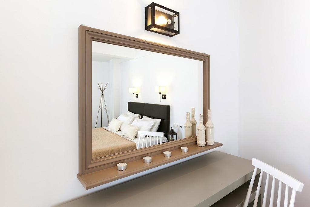 a mirror on a shelf with a bed in a room at Memories Beach Hotel in Monolithos