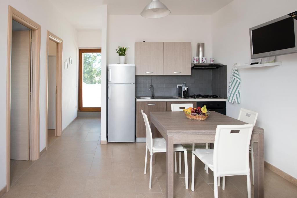 uma cozinha com uma mesa com cadeiras e um frigorífico em Il Delfino em Pisticci