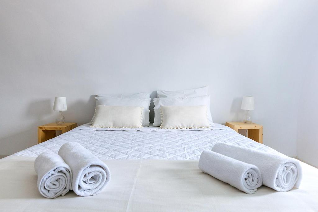 a bedroom with a white bed with towels on it at Memories Beach Hotel in Monolithos