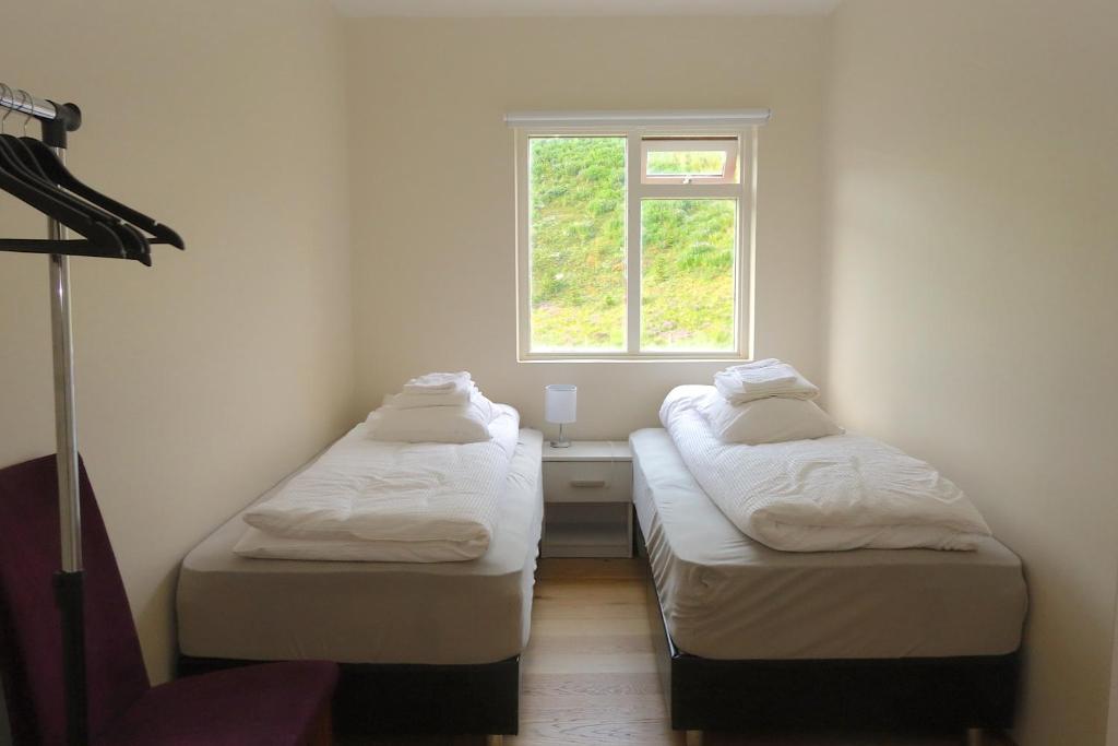 two beds in a small room with a window at Thorbrandsstadir Farm Holidays in Þorbrandsstaðir