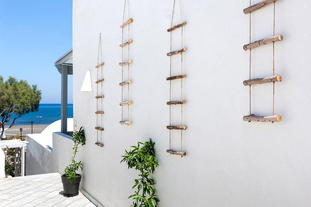 a white wall with some plants on it at Memories Beach Hotel in Monolithos