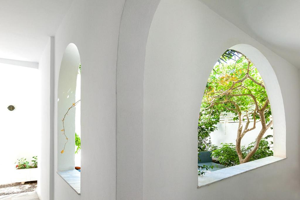 two mirrors on the wall of a room with white walls at Memories Beach Hotel in Monolithos