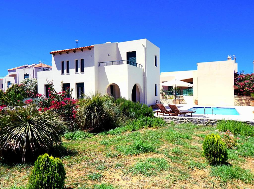 una casa blanca con una piscina frente a ella en Villa Anna en Asprouliánoi