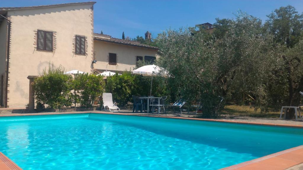 a swimming pool in front of a house at Borgo Montauto in San Gimignano