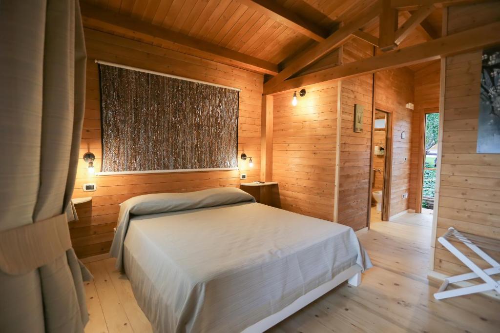 um quarto com uma cama num quarto com paredes de madeira em Il Refolo em Riardo