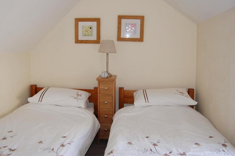 two beds sitting next to each other in a bedroom at May Cottage in Tideswell