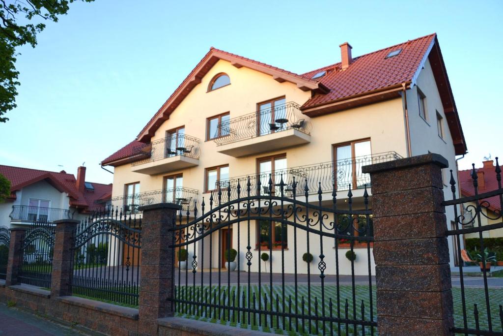 a large house with a black wrought iron fence at Wil-Art Jastarnia Pokoje i apartamenty in Jastarnia