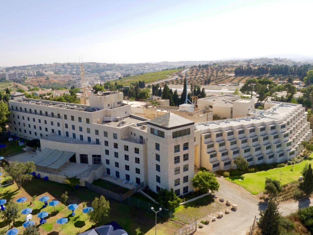 - une vue aérienne sur un grand bâtiment blanc dans l'établissement Ramat Rachel Resort, à Jérusalem