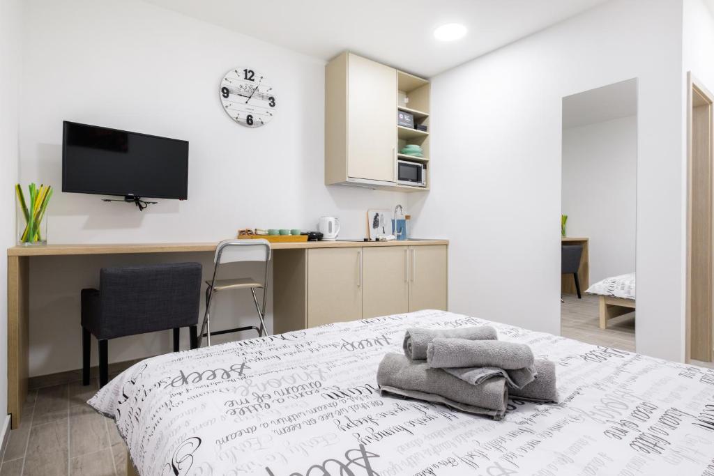 um quarto com uma cama e uma secretária com uma televisão em Apartments Lucky Place em Zagreb