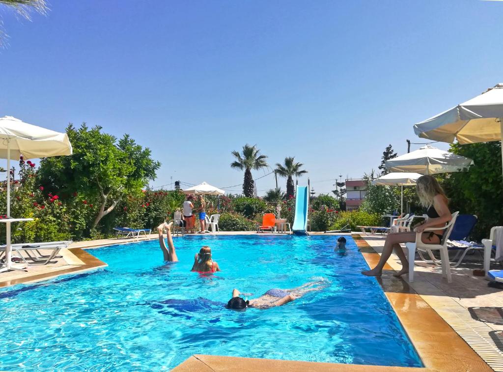 a group of people swimming in a swimming pool at Violetta Hotel in Amoudara Herakliou