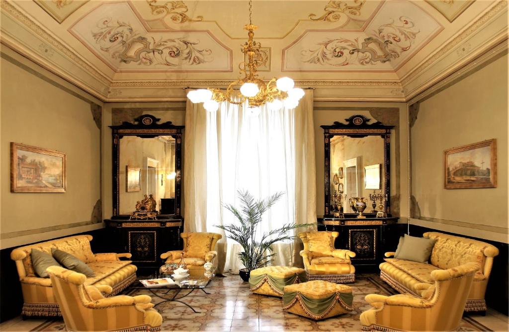 sala de estar con sillas y lámpara de araña en Historical Suites VVM, en Lecce