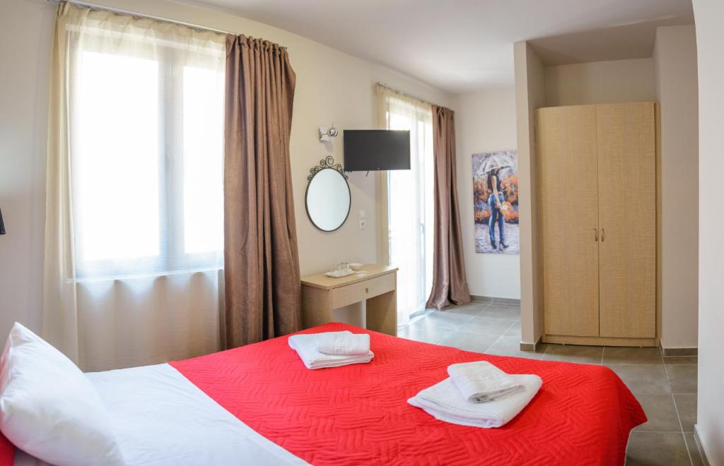 sypialnia z czerwono-białym łóżkiem i lustrem w obiekcie LUX Hotel w Pireusie