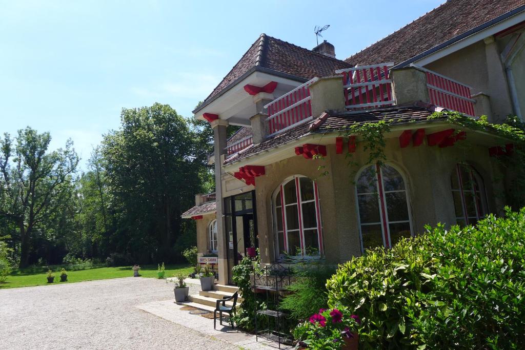 una casa con ventanas rojas y rosas. en Domaine de L'Arche de René au LAC DU DER, en Sainte-Livière