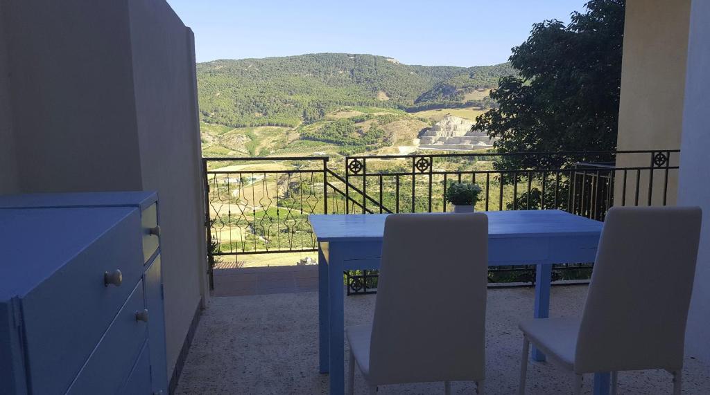 a blue table and chairs on a balcony with a view at Borgo Saraceno in Sambuca di Sicilia