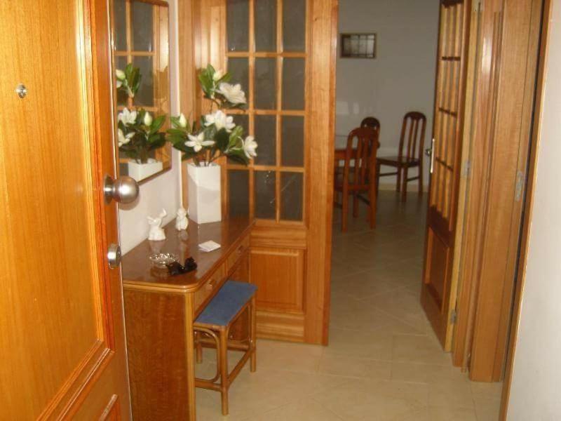 a room with a desk with a vase of flowers on it at Nice apartment near Faro's airport in Faro