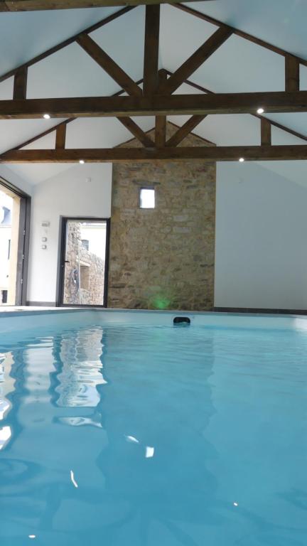 a swimming pool with blue water in a building at Domaine de Tréouzien in Plouhinec