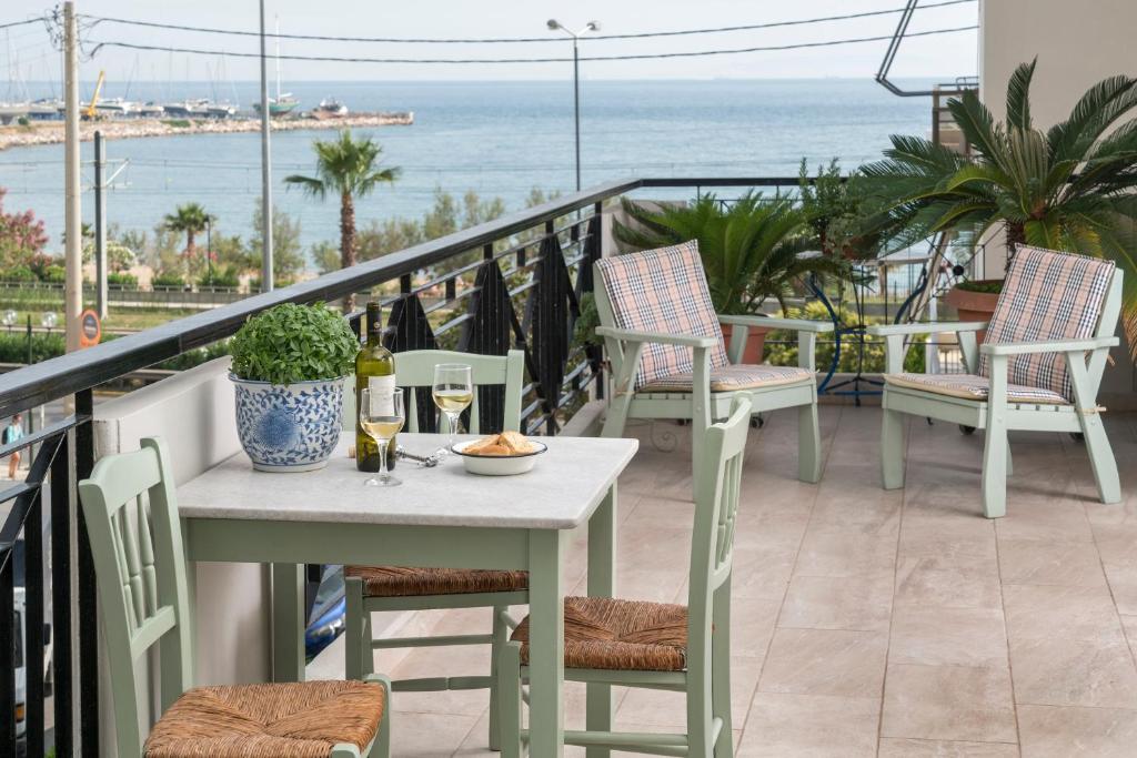 a table and chairs on a balcony with a view of the ocean at Unique Flat with Sea View at Edem Beach - A Seafront Property by Athenian Homes in Athens