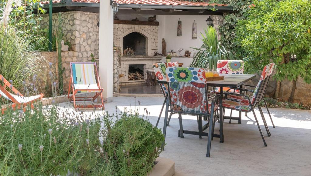 een patio met een tafel en stoelen en een open haard bij Apartments in Trogir in Trogir