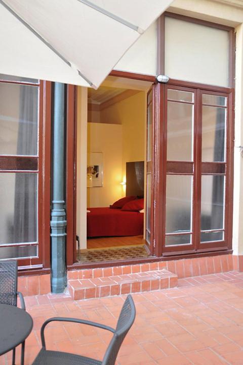a patio with a room with a red couch and a window at Center Gran Via in Barcelona