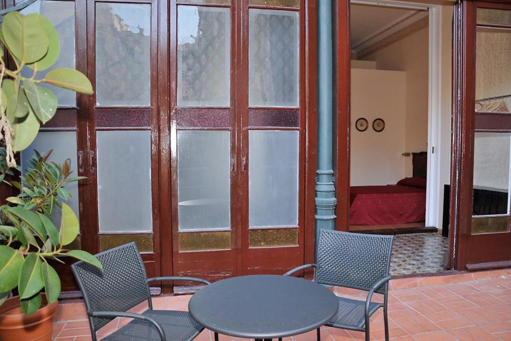 a patio with a table and chairs and a door at Center Gran Via in Barcelona