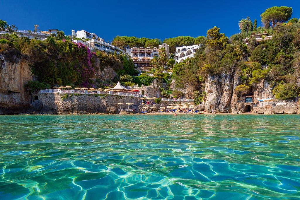 een uitzicht vanaf het water van een strand bij Grand Hotel Le Rocce in Gaeta