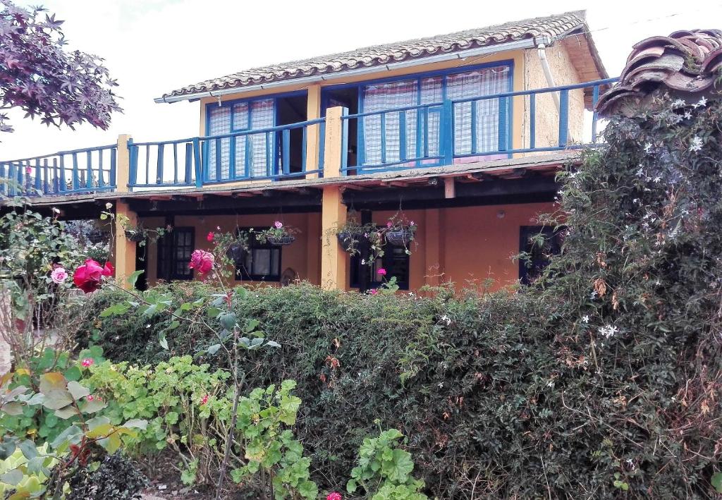 una casa con balcón sobre algunos arbustos en Finca Saron Hostería & Spa, en Sogamoso