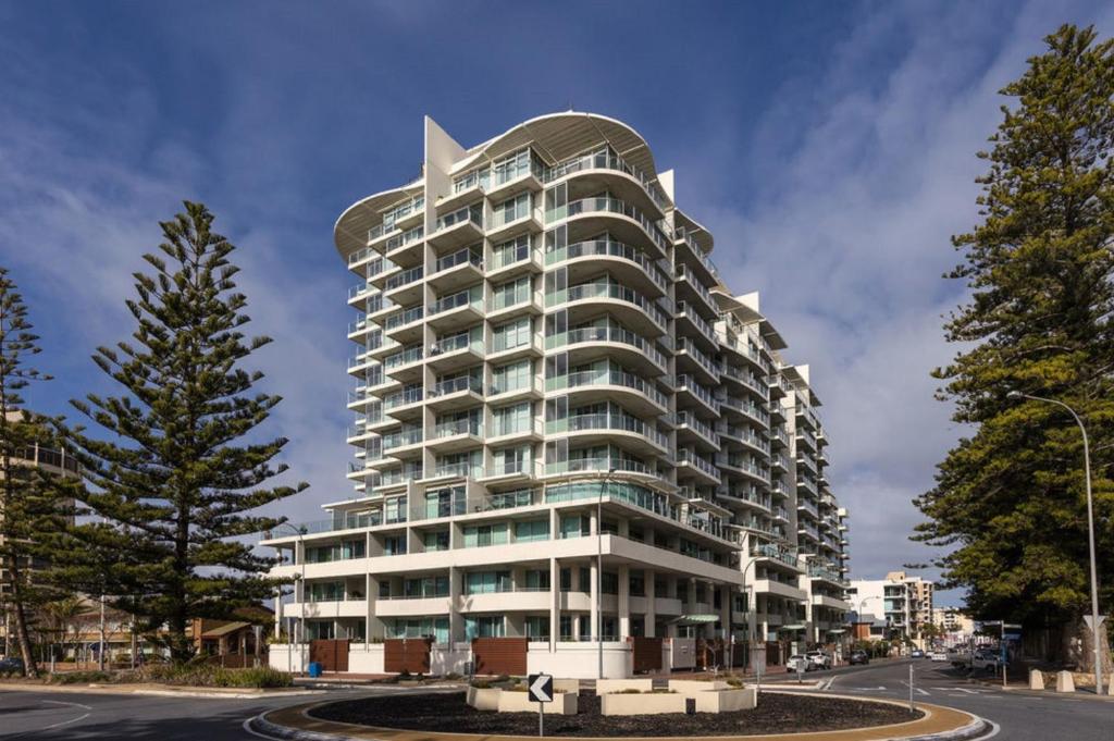 a tall white building with a curved roof at GlenelgApt in Adelaide