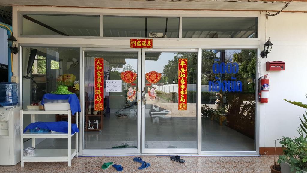 a store front with glass doors and red signs at Meaungkorn Villa in Fang