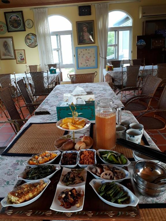 a table with many plates of food on it at Light and Shadow B&amp;B in Yuanshan