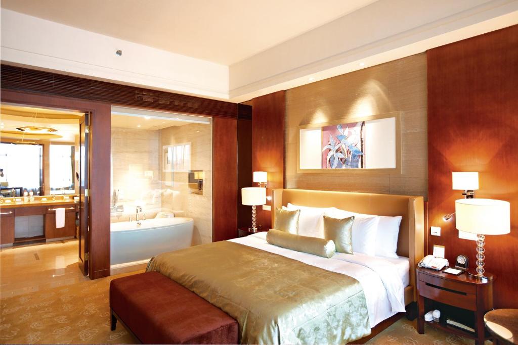 1 dormitorio con 1 cama grande y bañera en Quanzhou Guest House, en Quanzhou