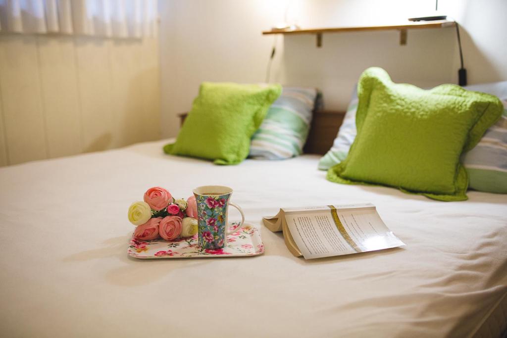 a tray with a cup and a book on a bed at Apartment Ema in Šibenik