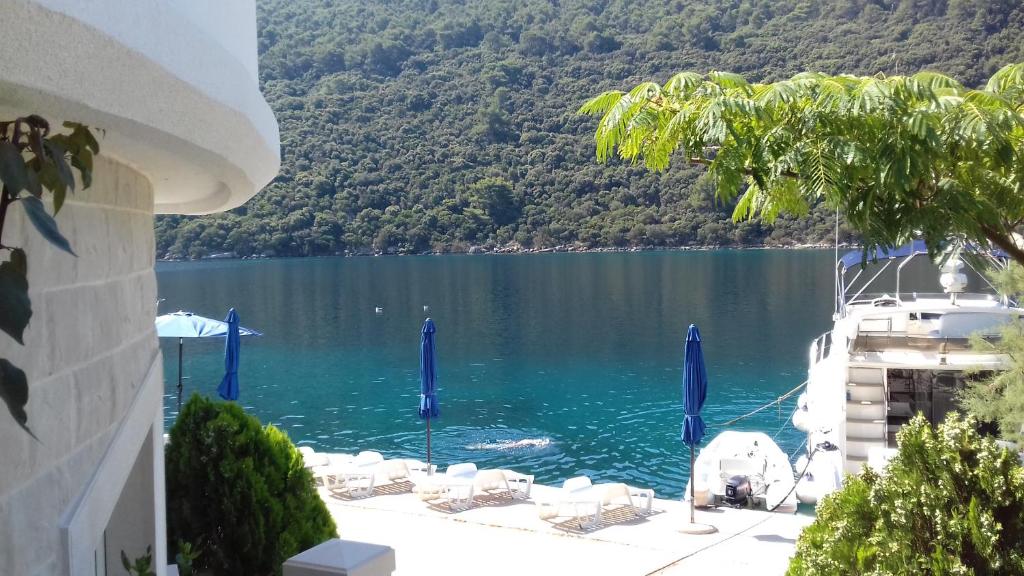 a view of a lake with chairs and a boat at Apartments Livia in Lastovo