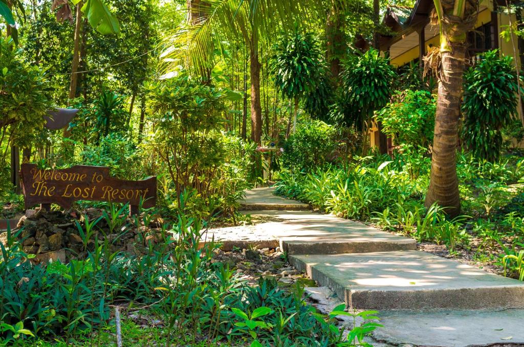 una señal en medio de un camino en un bosque en The Lost Resort, en Ko Samed