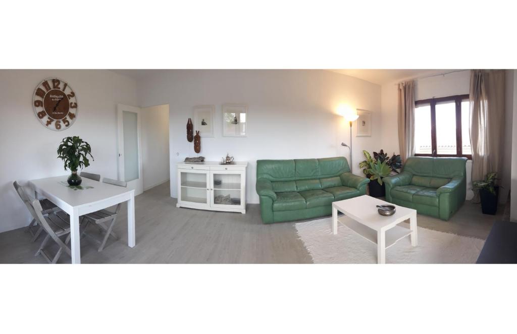 聖佩德羅－佩斯卡多爾的住宿－apartament Sant Pere，客厅配有两张绿色沙发和一张桌子