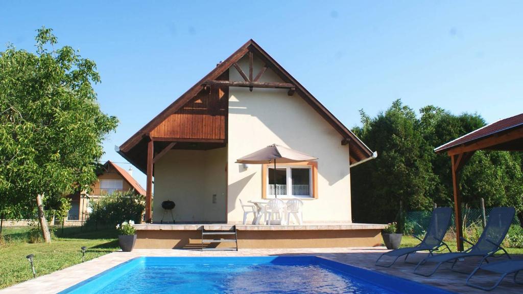a house with a swimming pool in front of it at Balaton Villa Gyenes in Gyenesdiás