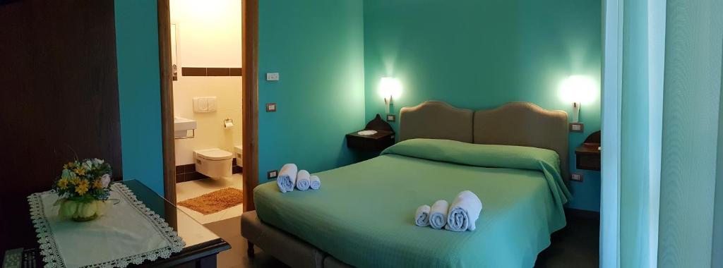 een slaapkamer met een groen bed en een spiegel bij Casa Del Sole in Soverato Marina
